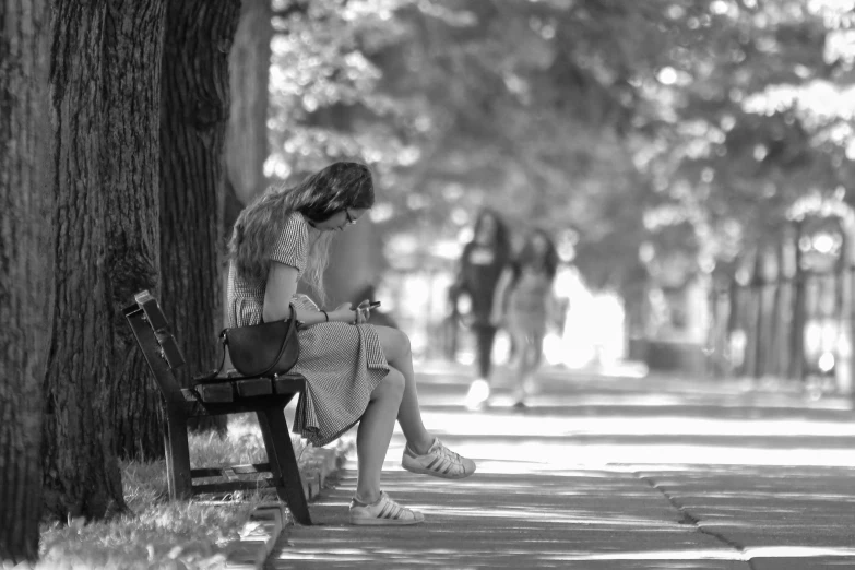 a black and white photo of a woman sitting on a bench, a picture, by Hristofor Zhefarovich, summer afternoon, girls, student, girl making a phone call