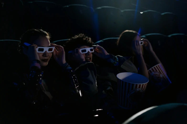 a group of people watching a movie with 3d glasses, a hologram, trending on pexels, fan favorite, horror movie scene, cinematic backlighting, movie still of a tired