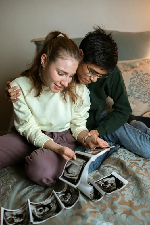 a couple of people that are sitting on a bed, a polaroid photo, happening, pregnant, opening scene, profile image, college students