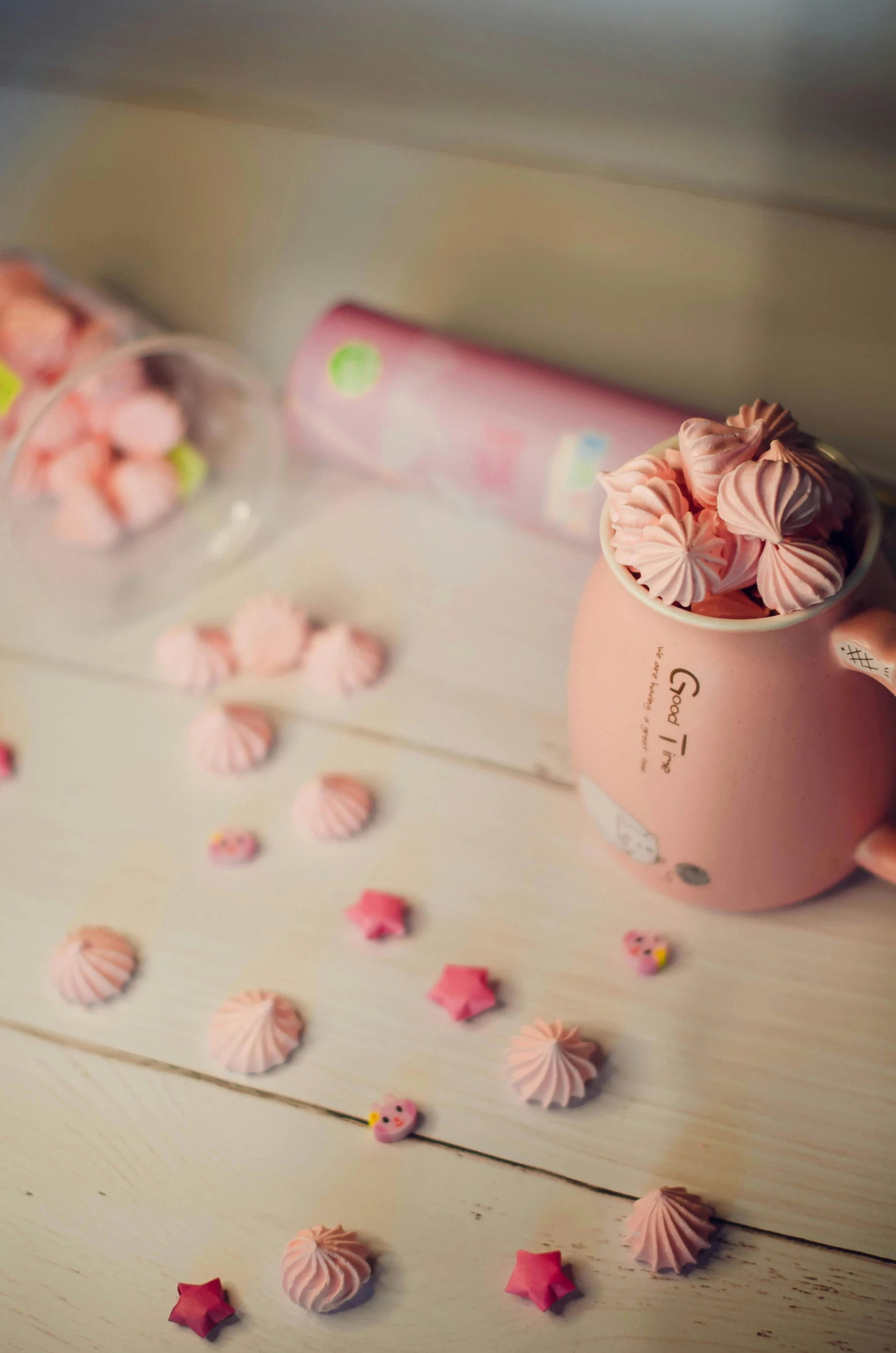 a pink cup sitting on top of a wooden table, candies, cutecore, sha xi, low quality photograph