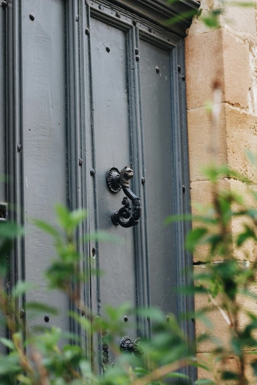 a close up of a door with a clock on it, by David Simpson, unsplash, made of wrought iron, cottage close up, grey, a small