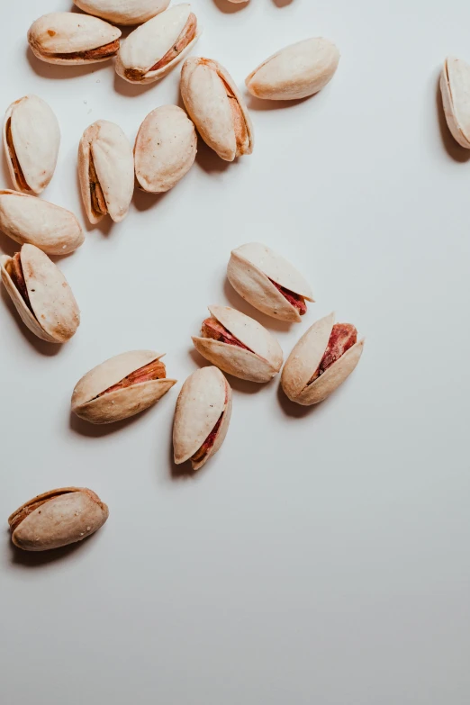 a pile of pistats sitting on top of a table, a macro photograph, trending on pexels, nut, on a pale background, 6 pack, opening shot