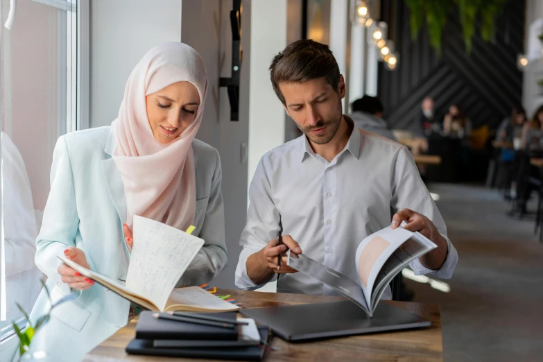 a man and a woman are sitting at a table, hurufiyya, studying, profile image, white hijab, commercial