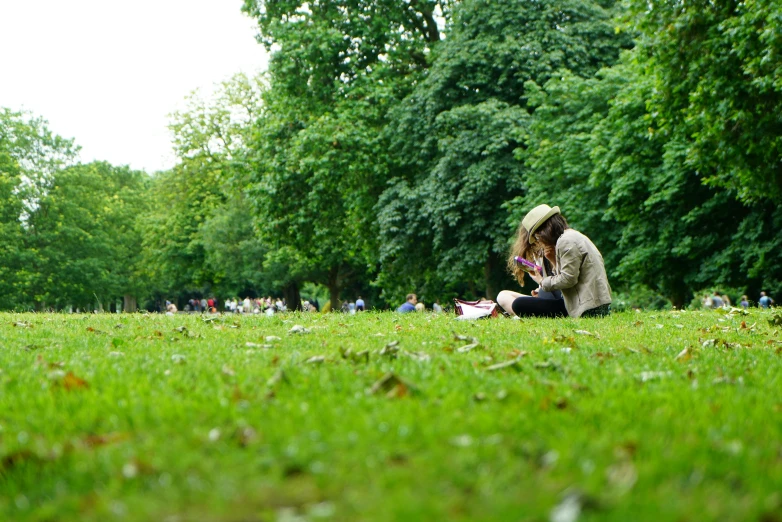 a couple sitting on top of a lush green field, pexels, plein air, reading under a tree, berlin park, some people are sitting, in london