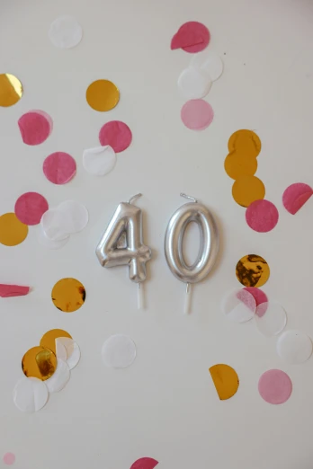 a cake with a number 40 on it surrounded by confetti, by Pamela Drew, unsplash, on a candle holder, made out of shiny silver, with a long, balloons