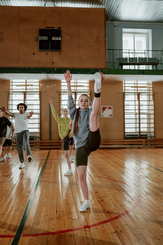 a group of people playing a game of frisbee, arabesque, in a gym, shot with sony alpha 1 camera, ussr, leg high