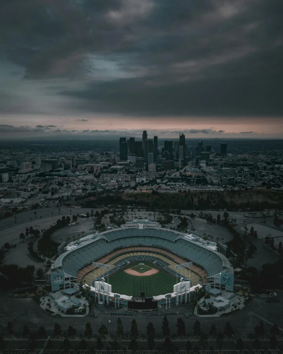 a baseball stadium with a cloudy sky in the background, by Kyle Lambert, unsplash contest winner, renaissance, los angeles at night, ariel view, grey skies with two rainbows, ☁🌪🌙👩🏾