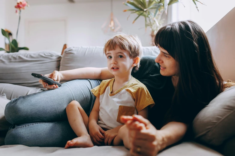 a woman and a child sitting on a couch, pexels, watching tv, avatar image, instagram photo, boy