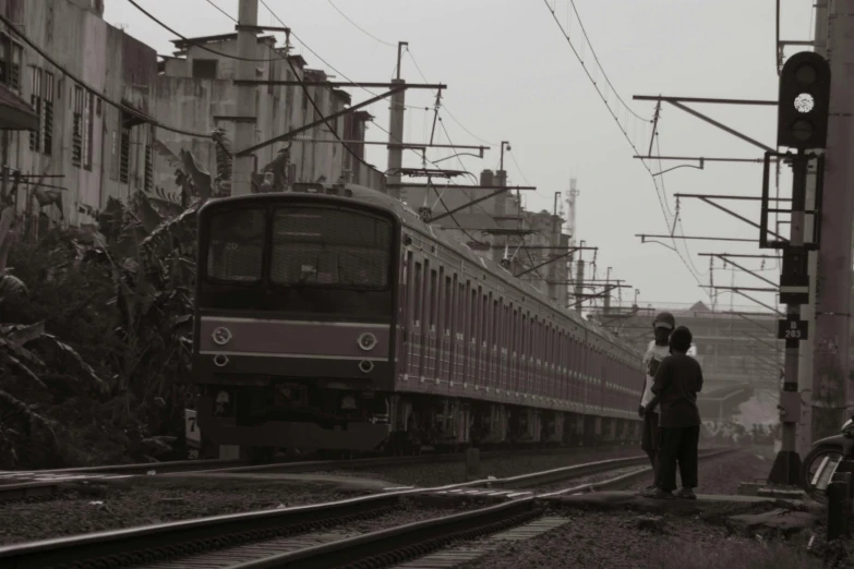 a black and white photo of a train on the tracks, by Yasushi Sugiyama, pexels contest winner, south jakarta, sepia, couple, :: morning
