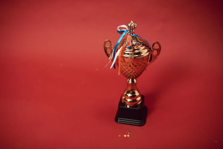 a close up of a trophy on a red surface, pexels contest winner, hight decorated, high quality upload, copper cup, gif