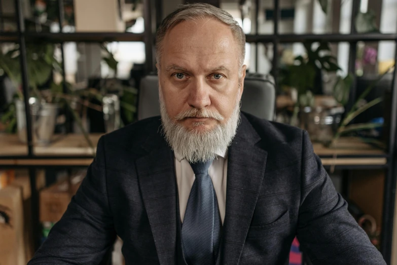 a man in a suit and tie sitting at a table, a portrait, by Adam Marczyński, pexels contest winner, renaissance, some grey hair in beard, in the office, yulia nevskaya, thumbnail