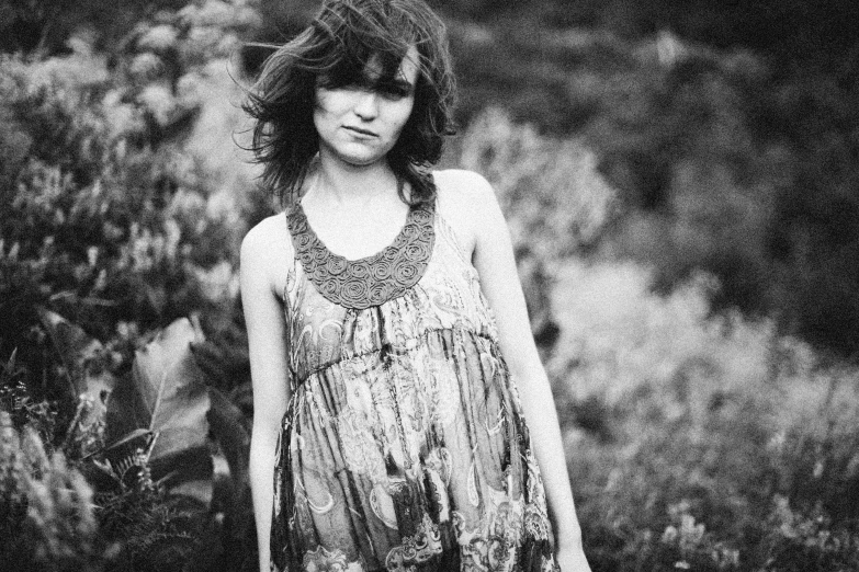 a black and white photo of a woman standing in a field, her hair is natural disheveled, organic dress, grimes, childish look