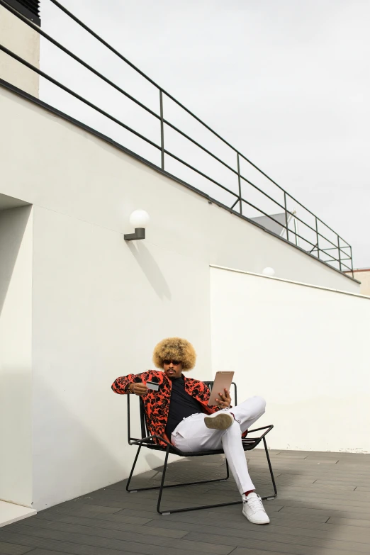 a woman sitting on a chair reading a book, inspired by Bauhaus, unsplash, modernism, rooftop party, with afro, leaning on the wall, graphic”