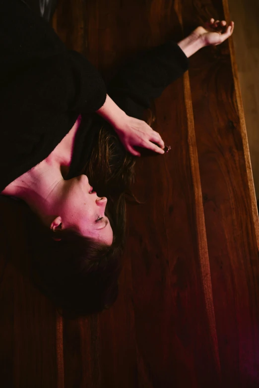 a woman laying on top of a wooden floor, unsplash, renaissance, captures emotion and movement, over vivid dark wood table, down there, emily rajtkowski
