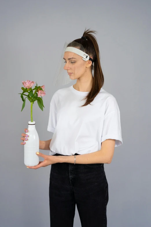 a woman holding a vase with a flower in it, glass oled visor head, dressed in a white t-shirt, wearing a headband, product - view