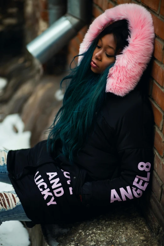 a woman with green hair sitting against a brick wall, an album cover, inspired by Wang E, pexels contest winner, graffiti, model wears a puffer jacket, pink fluffy fur, black angel wings, standing in the snow