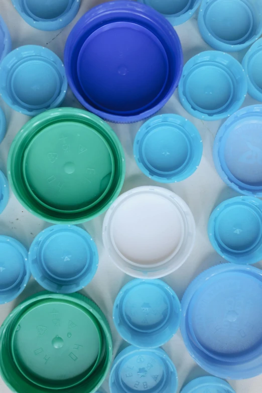 a plastic container filled with lots of different colored lids, by Doug Ohlson, plasticien, blue and green water, various sizes, light-blue, patterned
