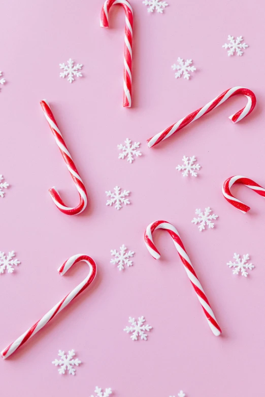 candy canes and snowflakes on a pink background, inspired by Peter Alexander Hay, pexels, snacks, thumbnail, petite, 12