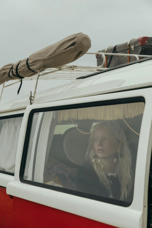 a woman sitting in the driver's seat of a red and white van, a picture, by Anna Boch, unsplash, portrait of elle fanning, a young female shaman, with a roof rack, kids