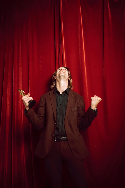 a man standing in front of a red curtain, pexels contest winner, renaissance, david spade, winning awards, ben folds portrait, man screaming