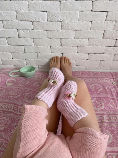 a woman laying on top of a bed next to a cup of coffee, an album cover, tumblr, wearing kneesocks, 🎀 🧟 🍓 🧚, crochet, highly realistic photo
