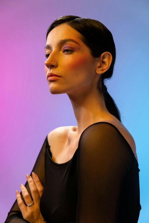 a woman in a black dress posing for a picture, inspired by Bert Stern, trending on pexels, color field, subtle multicolored light, cheekbones, yael shelbia, on a mannequin. studio lighting