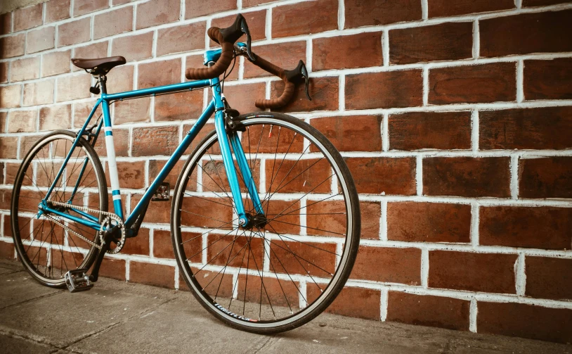 a blue bicycle leaning against a brick wall, pexels contest winner, aerodynamic frame, background image, indoor picture, brown and cyan blue color scheme