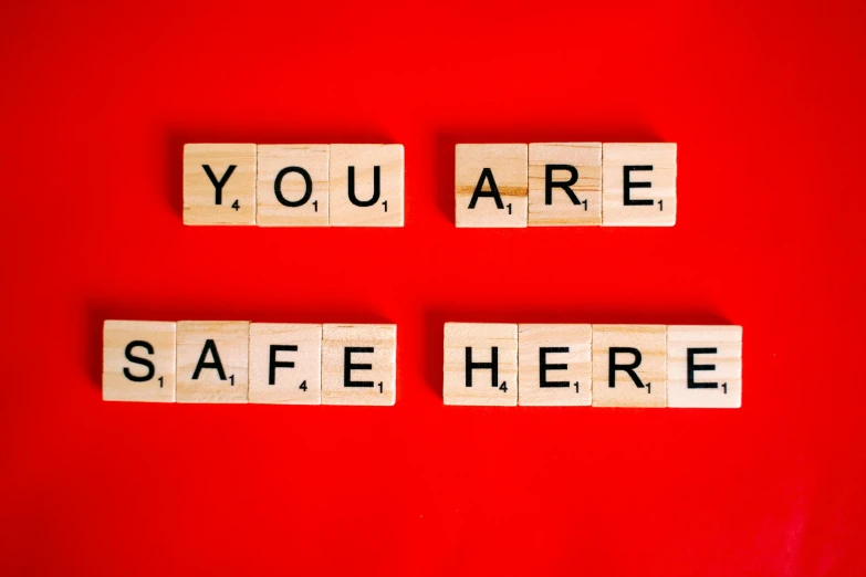 scrabbles spelling you are safe here on a red background, a picture, by Julia Pishtar, pexels, square, colorful signs, emergency countermeasures, ƒ/5.6