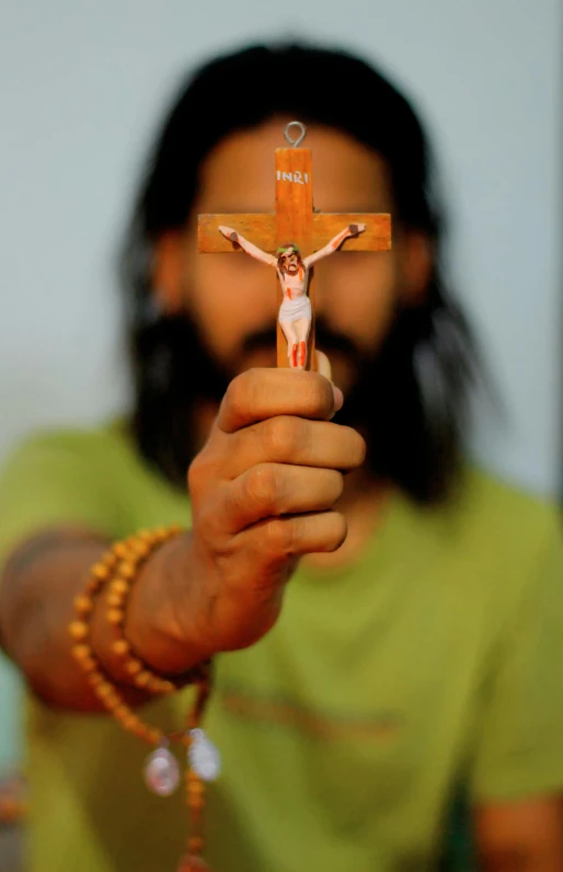 a close up of a person holding a cross, a picture, hurufiyya, provocative indian, ap photo, holy themed, contain