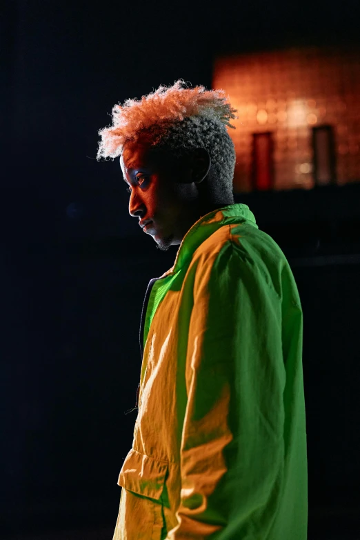 a man in a yellow and green jacket, an album cover, trending on pexels, afrofuturism, ray of light through white hair, 2 1 savage, concert photo, ( ( theatrical ) )