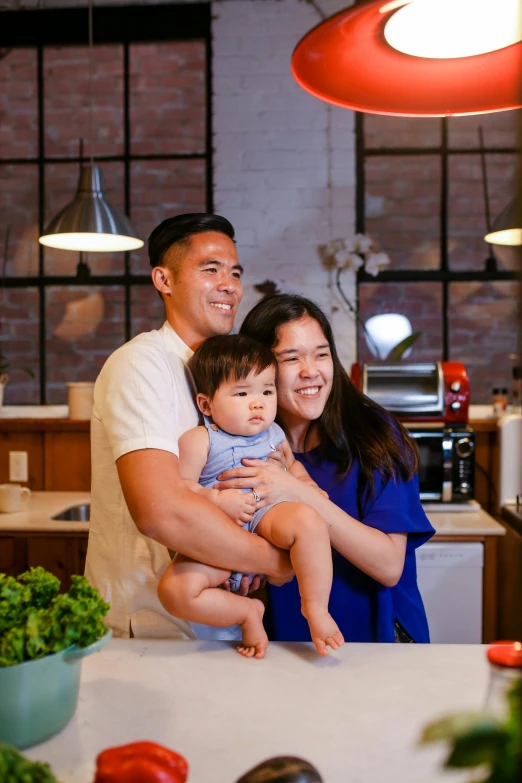 a man and woman holding a baby in a kitchen, darren quach, portrait image, seasonal, led