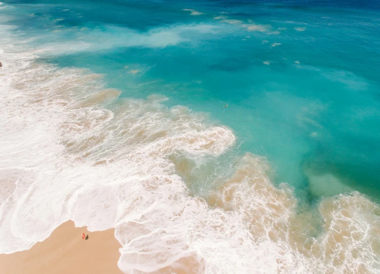 a large body of water next to a sandy beach, pexels contest winner, azure ocean, helicopter view, ocean spray, brightly colored