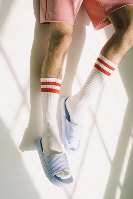 a man wearing pink shorts and white socks, left eye red stripe, detailed product shot, red stripe, a pair of ribbed