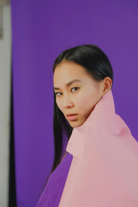 a woman standing in front of a purple wall, an album cover, inspired by Kim Tschang Yeul, trending on pexels, wearing collar on neck, at a fashion shoot, behind the scenes photo, bao pham