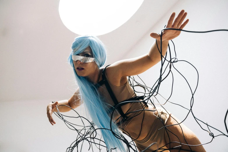 a woman with blue hair in a room, inspired by hajime sorayama, unsplash, conceptual art, thick wires looping, performance art, “house music rave with dancers, body harness