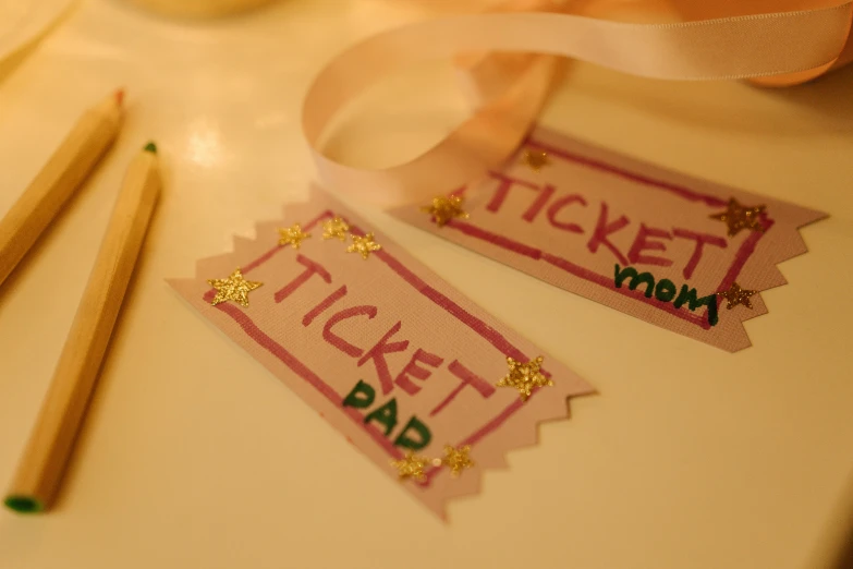 a couple of pencils sitting on top of a table, ticket, glitter sticker, thumbnail, craft