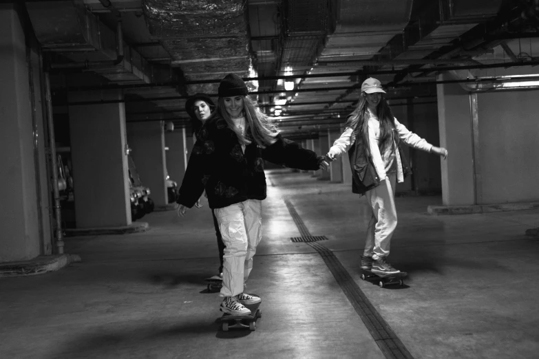 a couple of people riding skateboards in a parking garage, a black and white photo, lesbians, blackpink, photograph of three ravers, beautiful girls