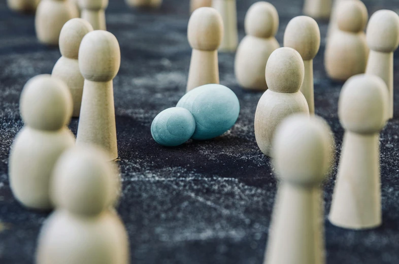 a group of wooden people standing around a blue egg, a marble sculpture, by Jesper Knudsen, unsplash, strategy game, crowds of people, medium shot of two characters, cult leader