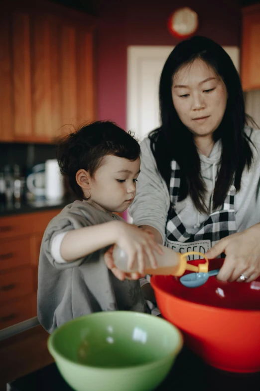 a woman and a child preparing food in a kitchen, inspired by Li Di, pexels, process art, square, color footage, foam, asian women