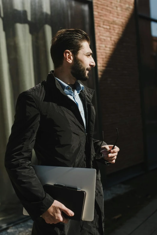 a man in a black jacket holding a laptop, pexels contest winner, renaissance, walking to the right, morning sunlight, well-groomed model, architect