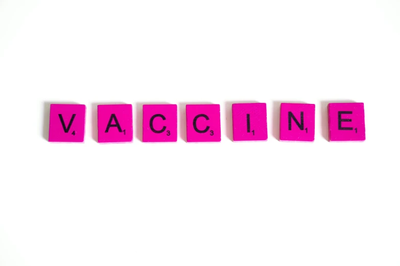 the word vaccine spelled in scrabbles on a white surface, by Rachel Reckitt, graffiti, pink, healthcare, vacuum, vacation