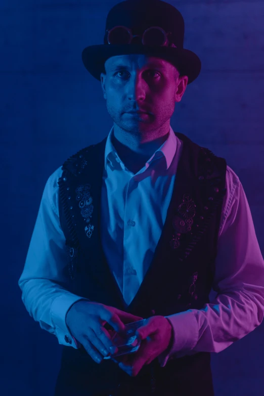 a man wearing a vest and a hat, a portrait, inspired by Byron Galvez, unsplash, blue and purle lighting, rob schneider, press shot, recital