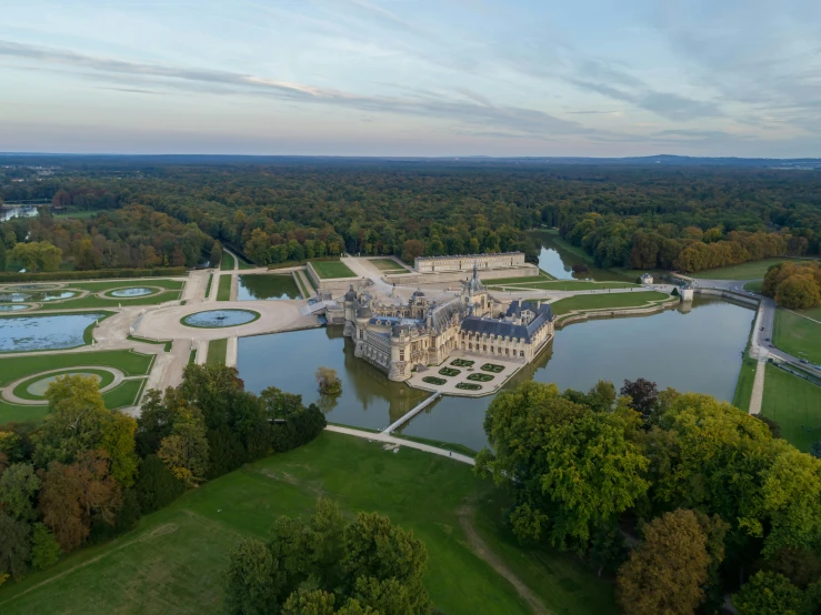 a large castle sitting on top of a lush green field, an album cover, by François Girardon, pexels contest winner, baroque, parks and lakes, aerial view cinestill 800t 18mm, pur champagne damery, high resolution image