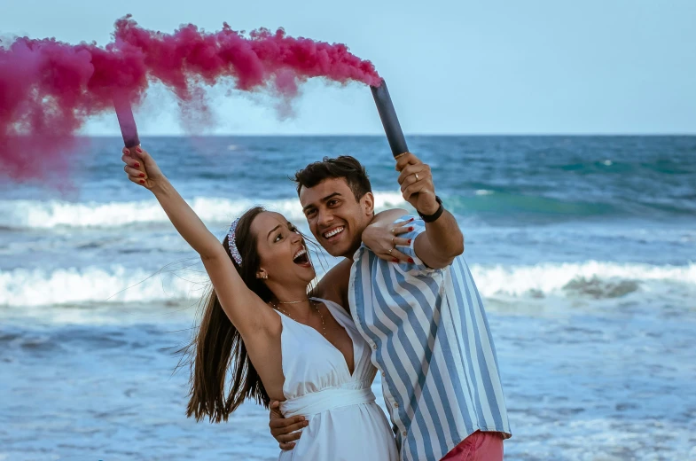 a man and woman standing next to each other on a beach, :6 smoke grenades, pink white turquoise, fun pose, holding a giant flail