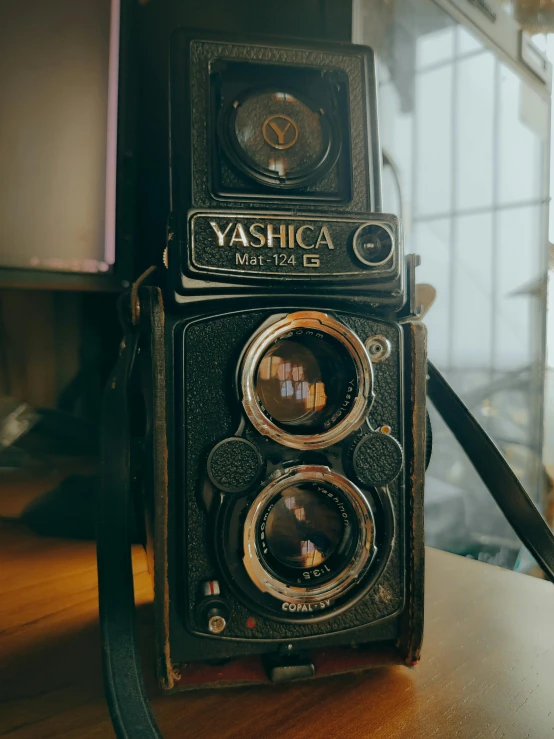 an old camera sitting on top of a wooden table, by Yasushi Sugiyama, unsplash contest winner, visual art, instagram story, medium format, yashica t 4, 4k museum photograph