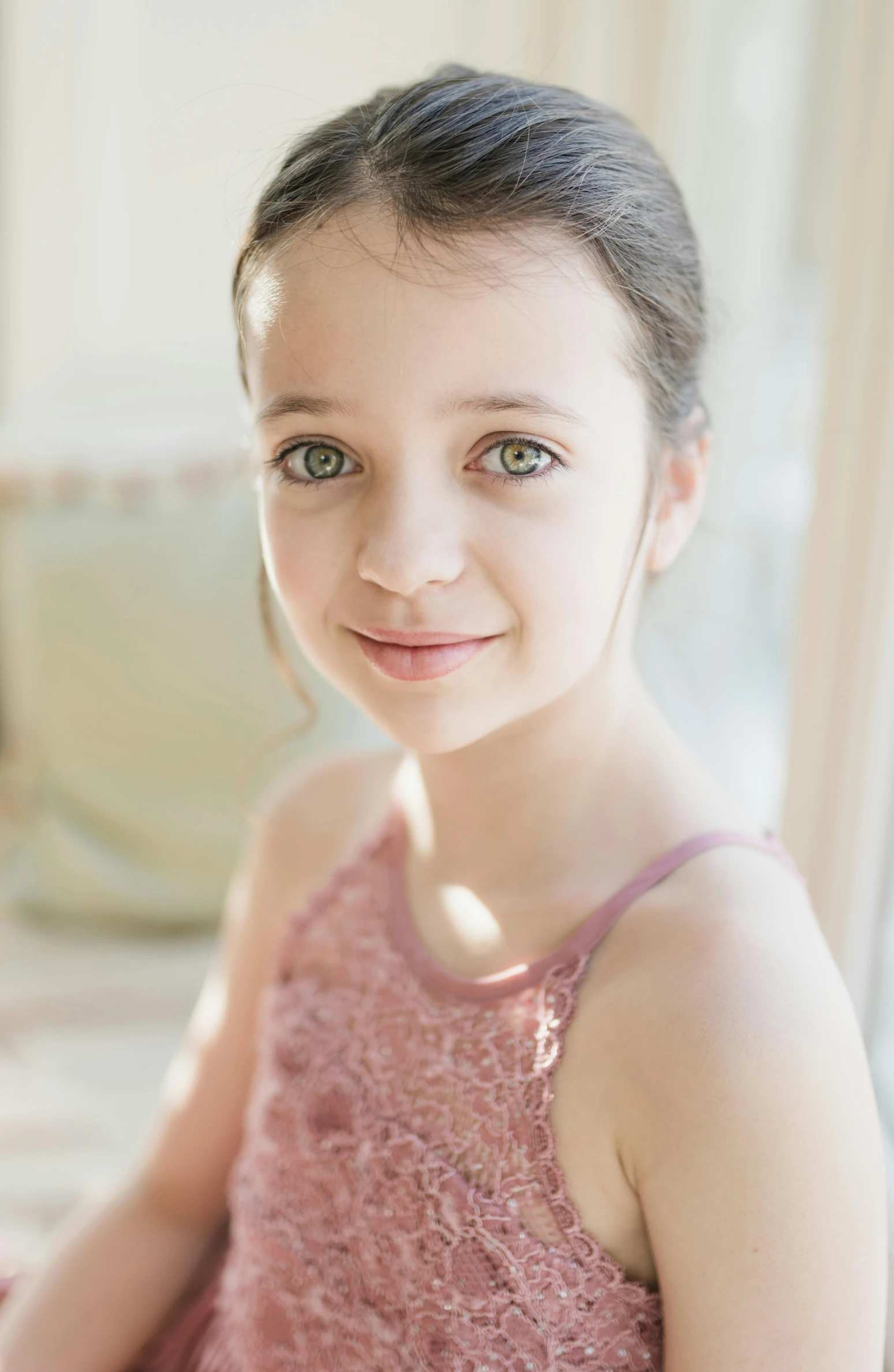 a young girl in a pink dress posing for a picture, soft green natural light, she is facing the camera, neutral focused gaze, prima ballerina