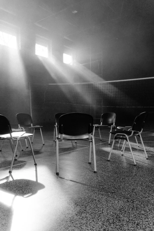 a black and white photo of a volleyball court, by Lucia Peka, unsplash contest winner, light and space, old chairs, theater dressing room, light glare, dystopian mood