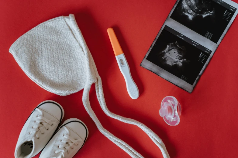 a pair of white shoes sitting on top of a red table, by Julia Pishtar, pexels contest winner, membrane pregnancy sac, colorful medical equipment, on a canva, the birth