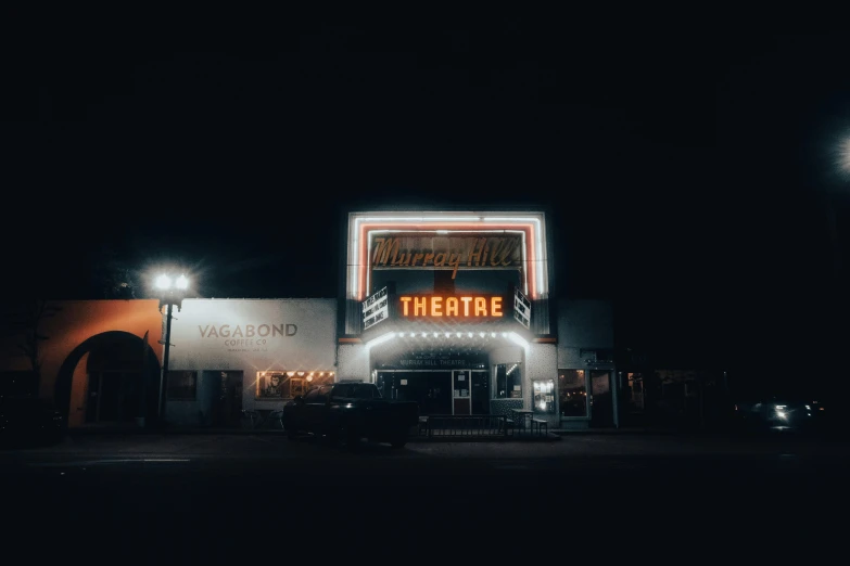 a theater marquee lit up at night, unsplash contest winner, magic realism, small town, dark and beige atmosphere, ( ( theatrical ) ), road trip