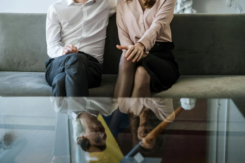 a man and a woman sitting on a couch, pexels contest winner, reflections on a glass table, lachlan bailey, sitting in office, closeup portrait shot